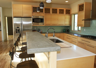 A kitchen wooden cabinetry and stone counters